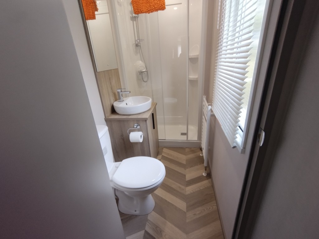 Large walk in shower along wuth sink, storage and toilet inside a static caravan holiday rental in Trethiggey Newquay Cornwall. Holiday park, static van. 4 birth, rental