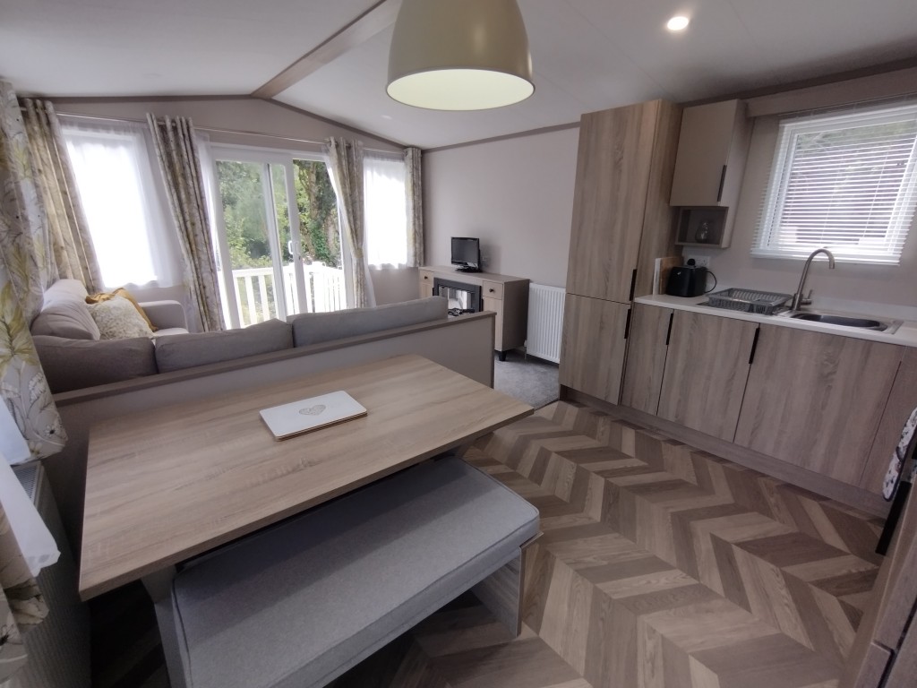 Dining area in our Newquay holiday rental. Static caravan dining room, table, bench seats, large modern kitchen. Newquay Cornwall, 4 birth holiday rental.
