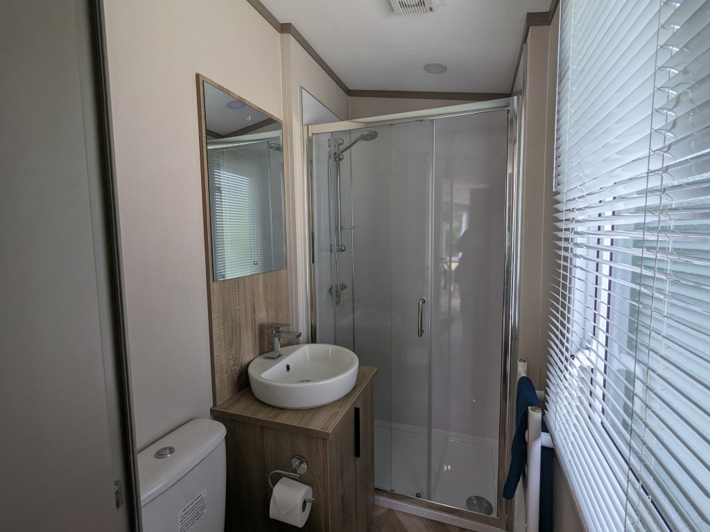 large bathroom with walk in shower, toilet and sink in a static caravan in Newquay Cornwall